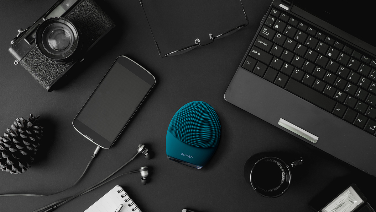 FOREO LUNA4 men on the table with a laptop and a mobile phone