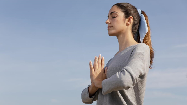 Young woman standing in the fresh air meditating